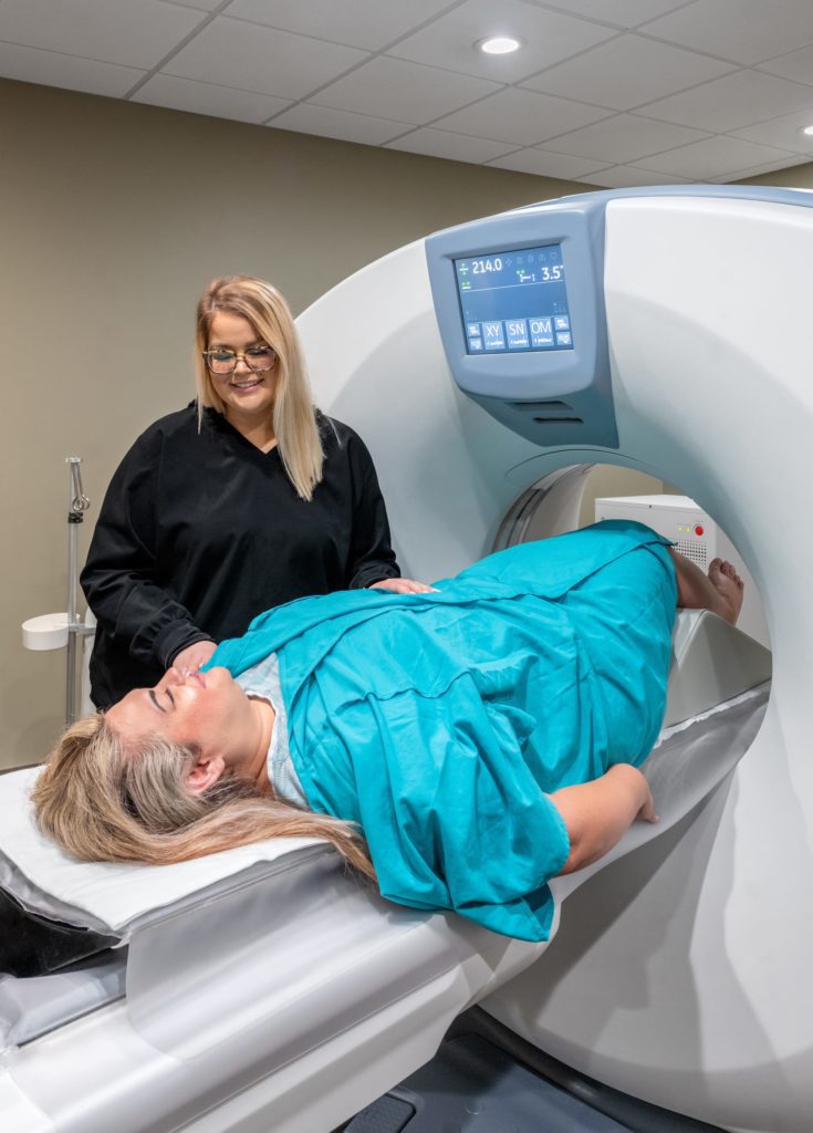 Patient getting ready for a CT scan at Touchstone Medical Imaging with a radiology technician's help