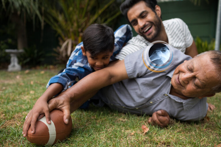 Father Grandfather and Boy playing football and grandfather has shoulder pain
