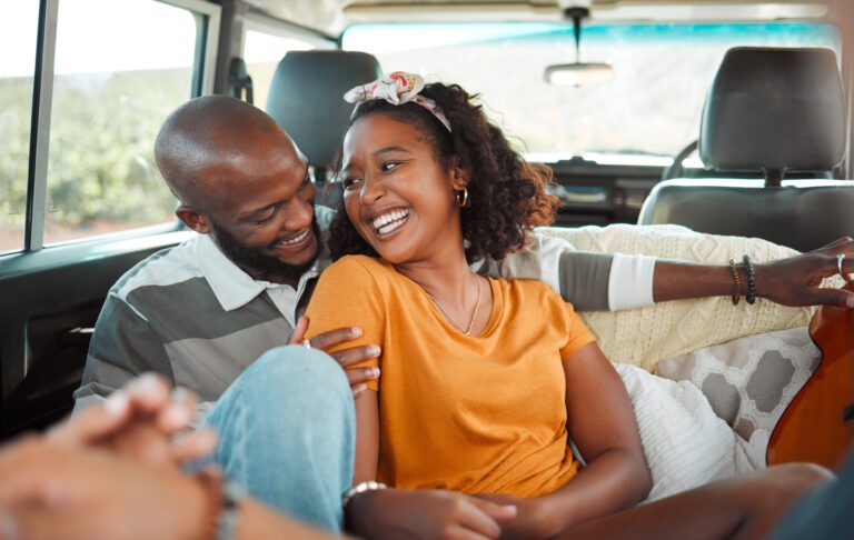 couple on a road trip, talking, laughing and bonding in a car together.