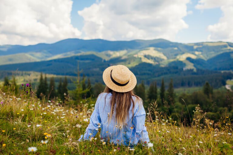 Tourist relaxing breathing fresh air and enjoying view of mountain.