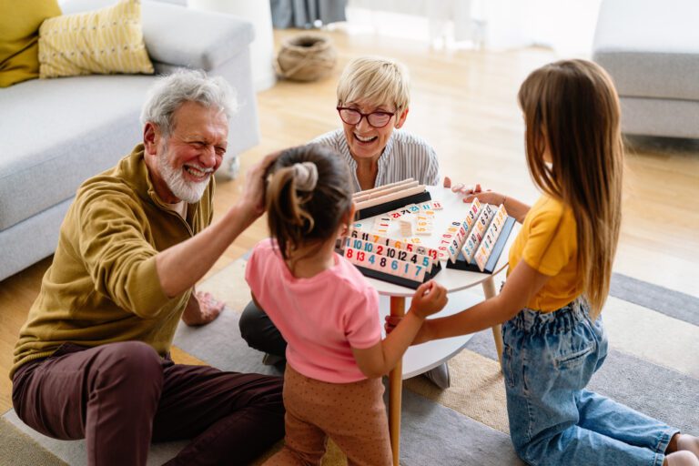Portrait of happy elderly couple and grandchildren playing together.